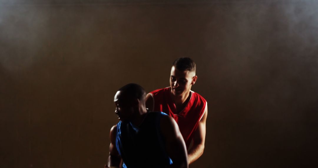 Two Athletes Playing Basketball in Darkened Indoor Court - Free Images, Stock Photos and Pictures on Pikwizard.com