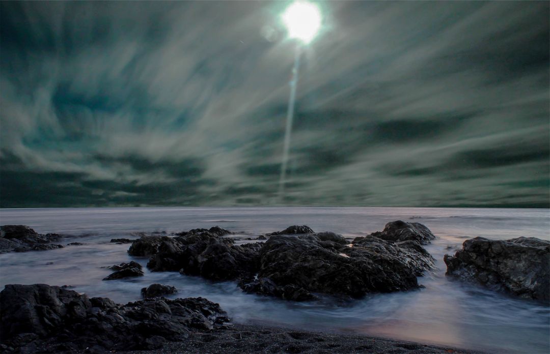 Moonlit Seascape with Rocks under Cloudy Night Sky - Free Images, Stock Photos and Pictures on Pikwizard.com