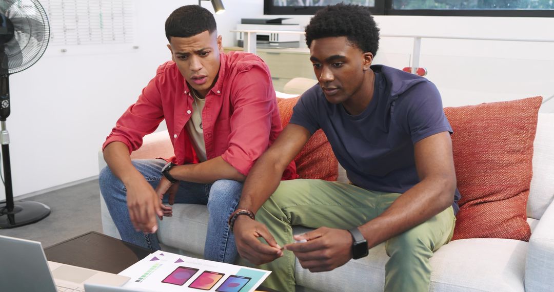 Two Coworkers Discussing Smartphone Concepts in Modern Office Lounge