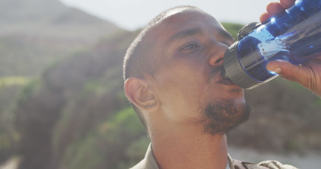 Man with Blue Water Bottle Hydrating Outdoors - Free Images, Stock Photos and Pictures on Pikwizard.com