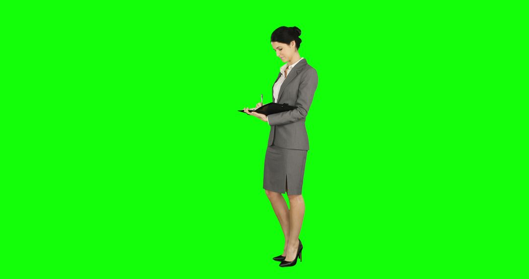 Businesswoman Taking Notes on Green Screen Background - Free Images, Stock Photos and Pictures on Pikwizard.com