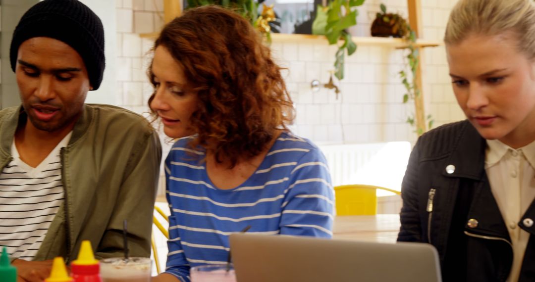 Group Collaboration on Laptop in Casual Workspace