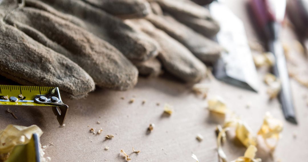 Close-up of Carpenter Tools and Work Gloves on Wood Workshop Table