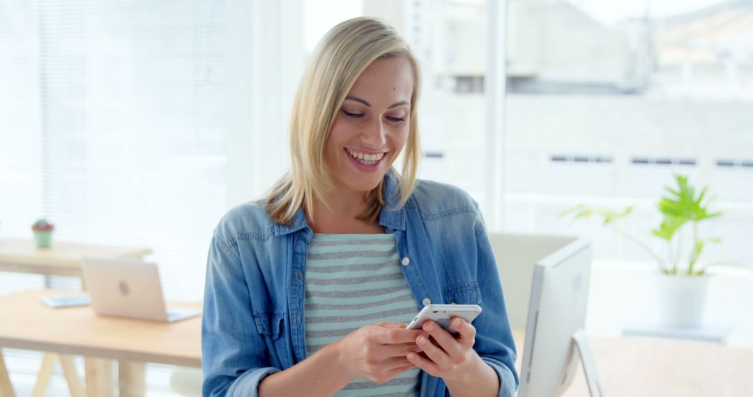 Smiling Woman in Office Using Smartphone - Free Images, Stock Photos and Pictures on Pikwizard.com