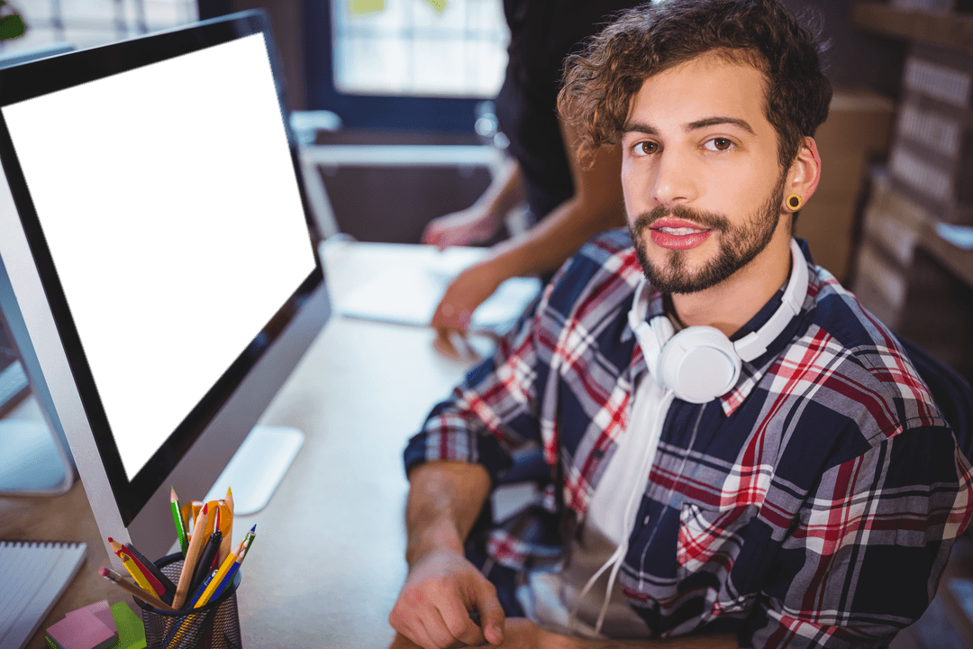Young Professional with Headphones in Creative Workspace with Transparent Monitor