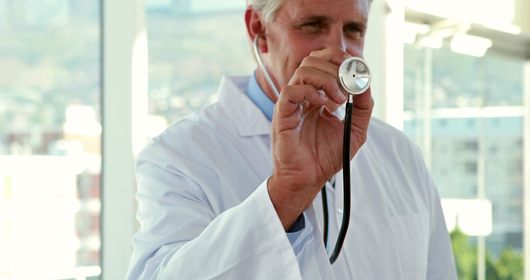 Senior Doctor Holding Stethoscope in Hospital - Free Images, Stock Photos and Pictures on Pikwizard.com