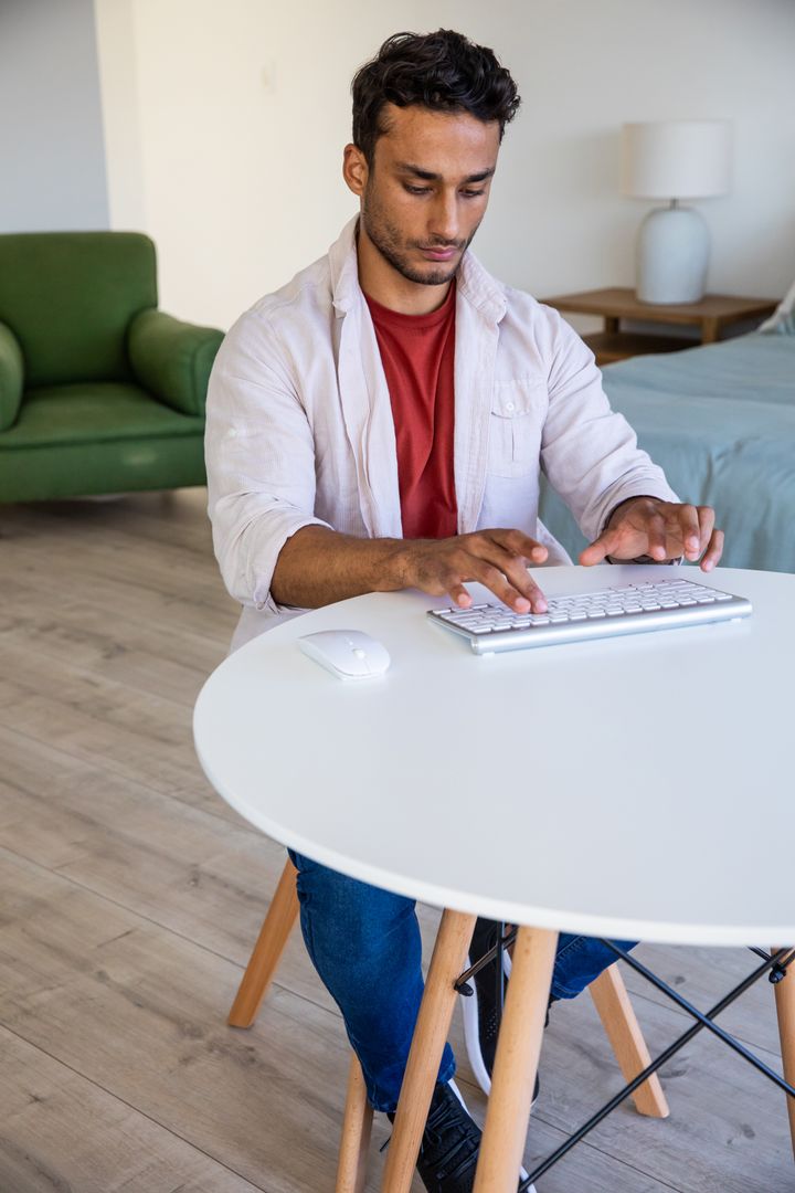 Man Working on Wireless Keyboard in Minimalist Home Office