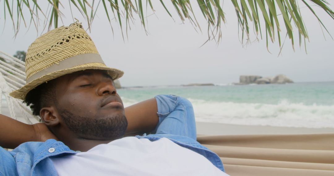 African American Man Relaxing in Hammock on Beachfront