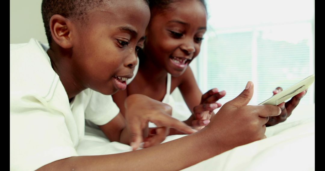 African American Children Having Fun with Smartphone at Home - Free Images, Stock Photos and Pictures on Pikwizard.com