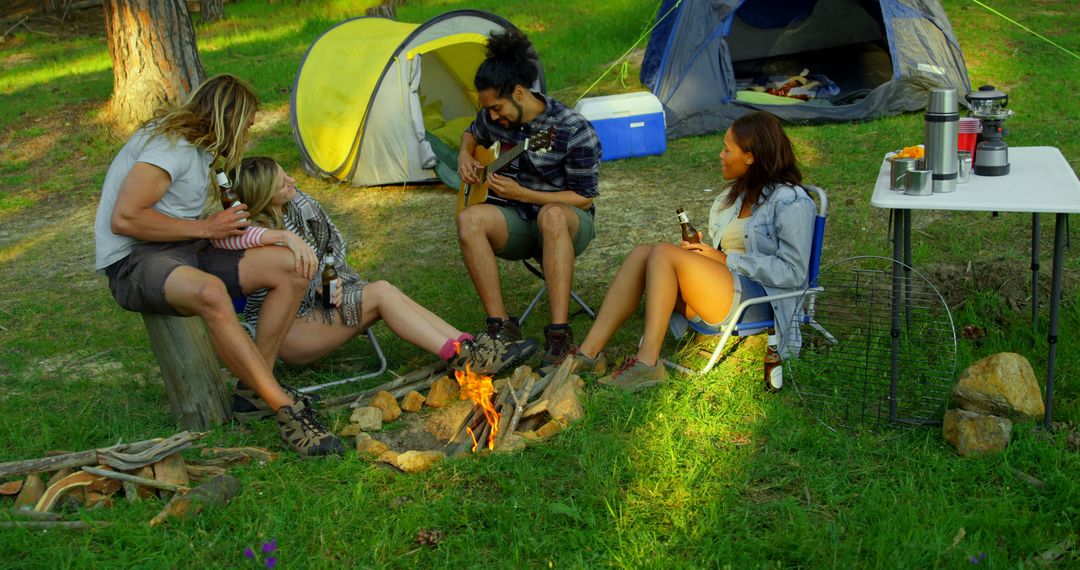 Group of Friends Enjoying Camping Trip with Acoustic Guitar Near Campfire - Free Images, Stock Photos and Pictures on Pikwizard.com