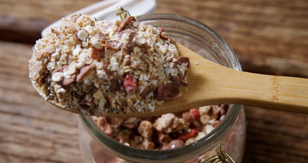 Spoonful of Homemade Granola with Dried Fruit in Glass Jar - Free Images, Stock Photos and Pictures on Pikwizard.com