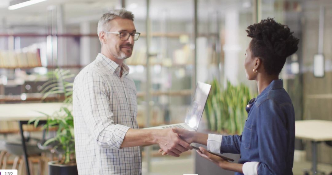 Colleagues Shaking Hands in Modern Office for Professional Collaboration