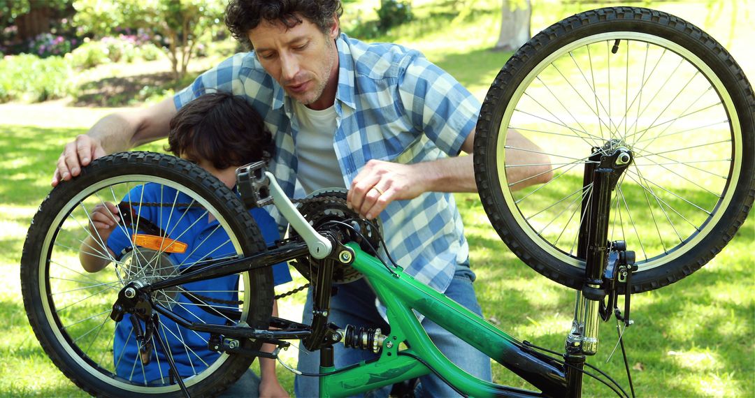 Father and Son Repairing Bicycle Outdoors Together - Free Images, Stock Photos and Pictures on Pikwizard.com