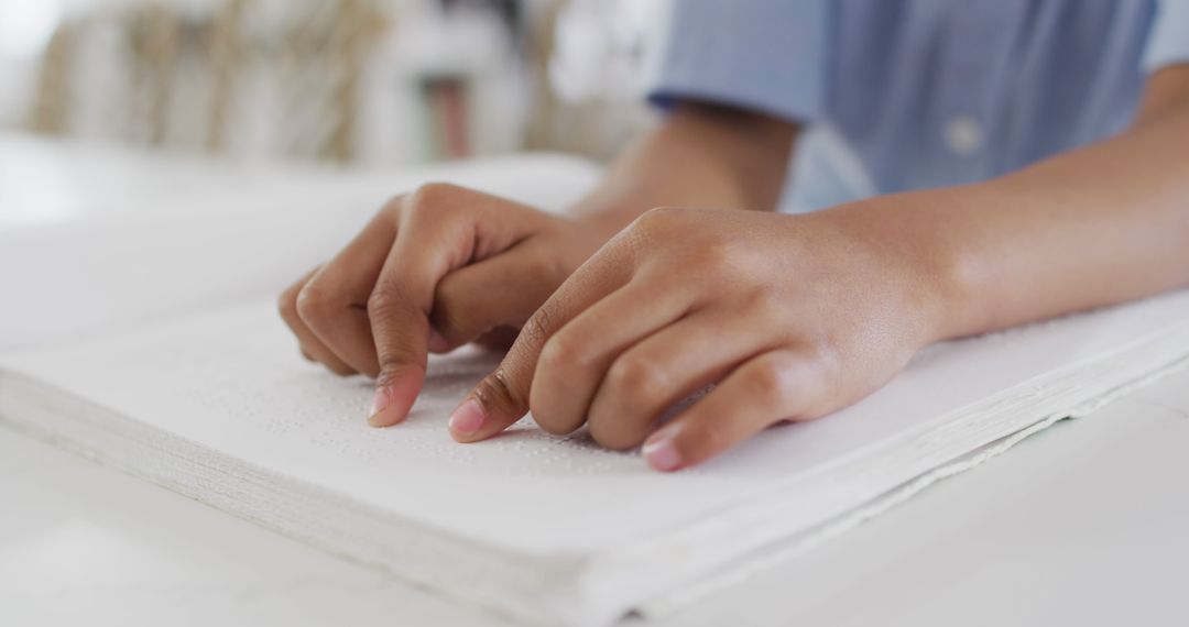 Close up of african american boy sitting at table and reading braille - Free Images, Stock Photos and Pictures on Pikwizard.com