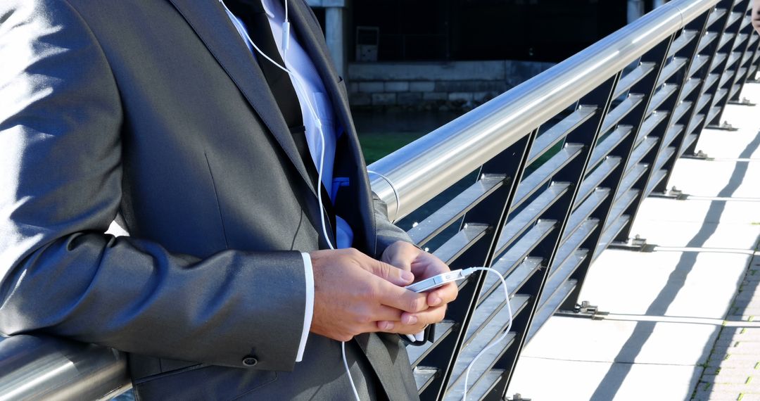 Businessman Using Smartphone Outdoors on Bridge - Free Images, Stock Photos and Pictures on Pikwizard.com