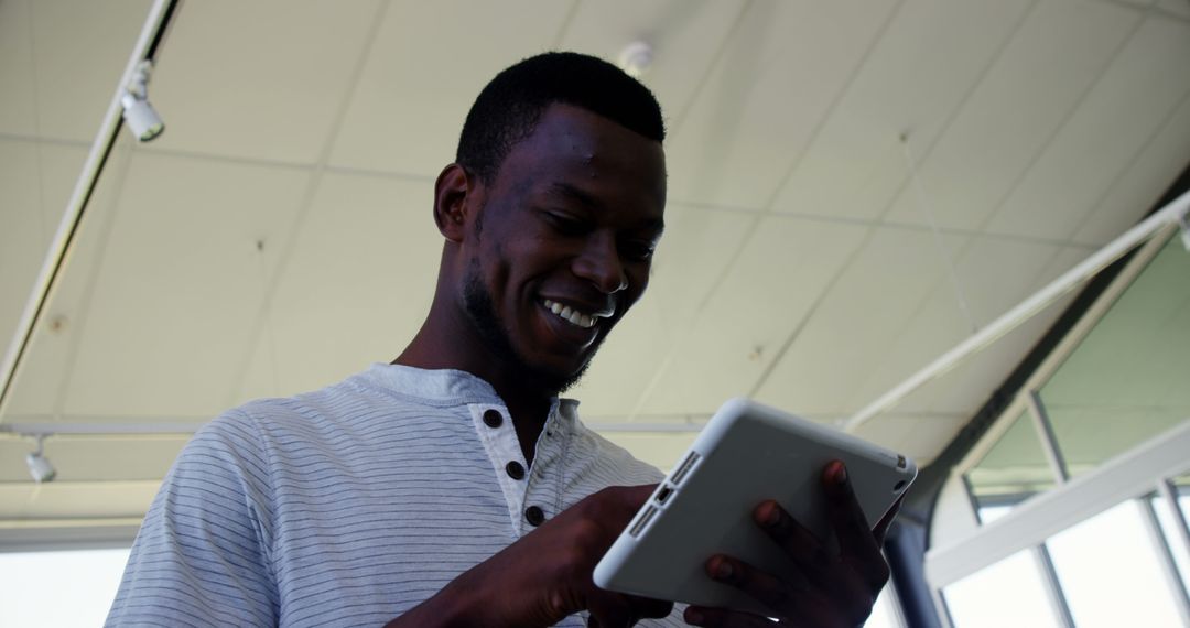 Smiling Professional Engaged with Tablet in Modern Workspace