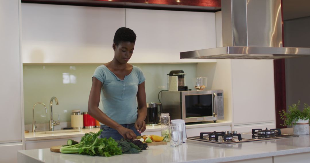 African American Woman Preparing Salad in Contemporary Kitchen - Free Images, Stock Photos and Pictures on Pikwizard.com