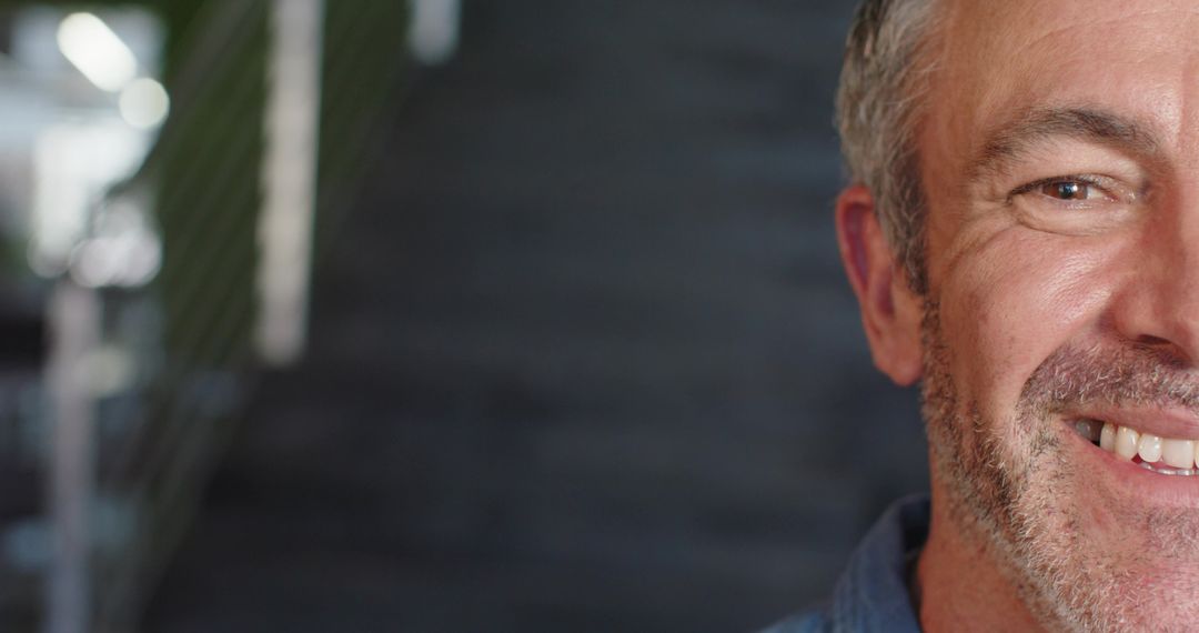 Smiling mature man on staircase with copy space for friendly business headshot