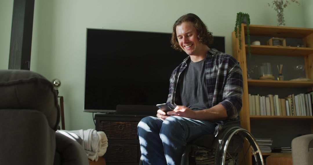 Man in Wheelchair Smiling While Using Smartphone at Home - Free Images, Stock Photos and Pictures on Pikwizard.com