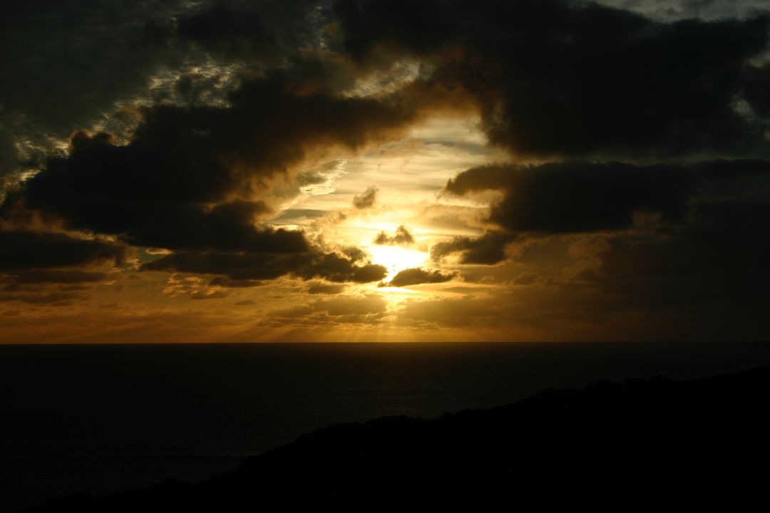Dramatic Sunset Over Ocean with Dark Clouds - Free Images, Stock Photos and Pictures on Pikwizard.com