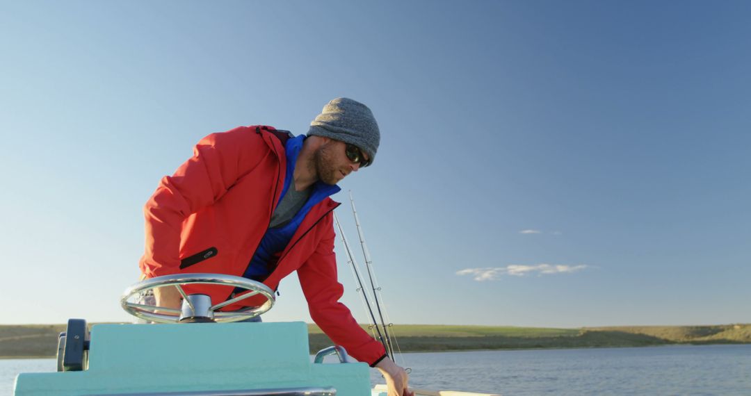 Man Steering Boat on Sunny Day with Clear Sky