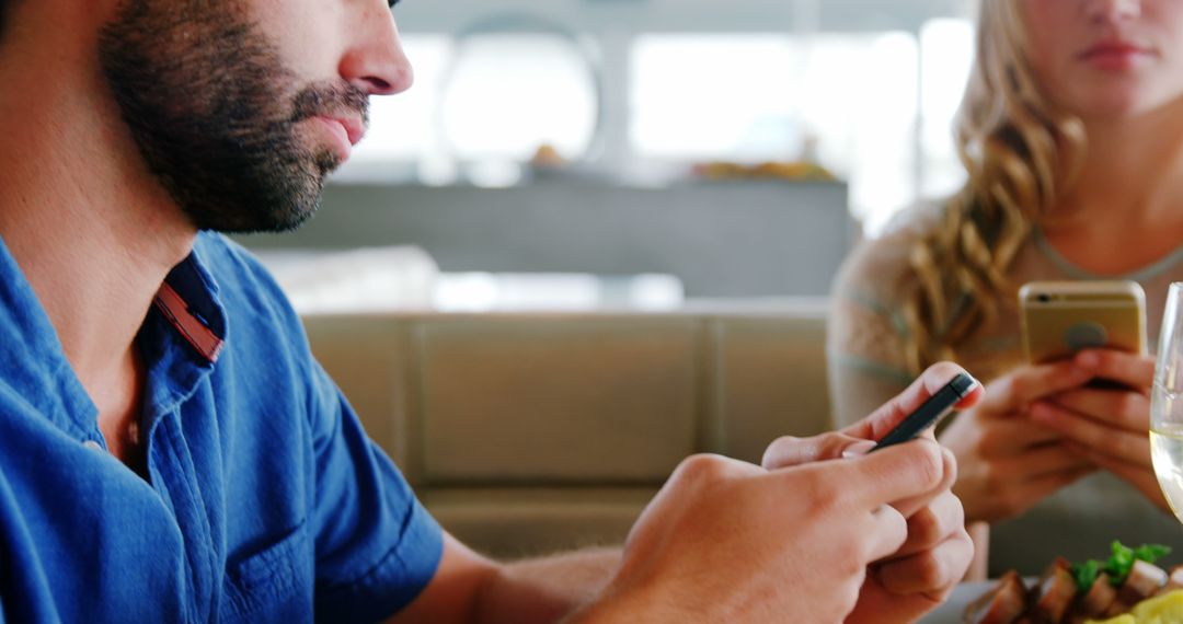 Couple Distracted by Smartphones at Restaurant