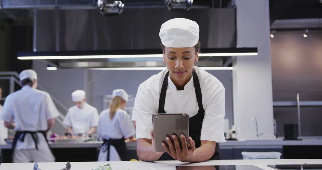 Female Chef Using Digital Tablet in Modern Kitchen - Free Images, Stock Photos and Pictures on Pikwizard.com