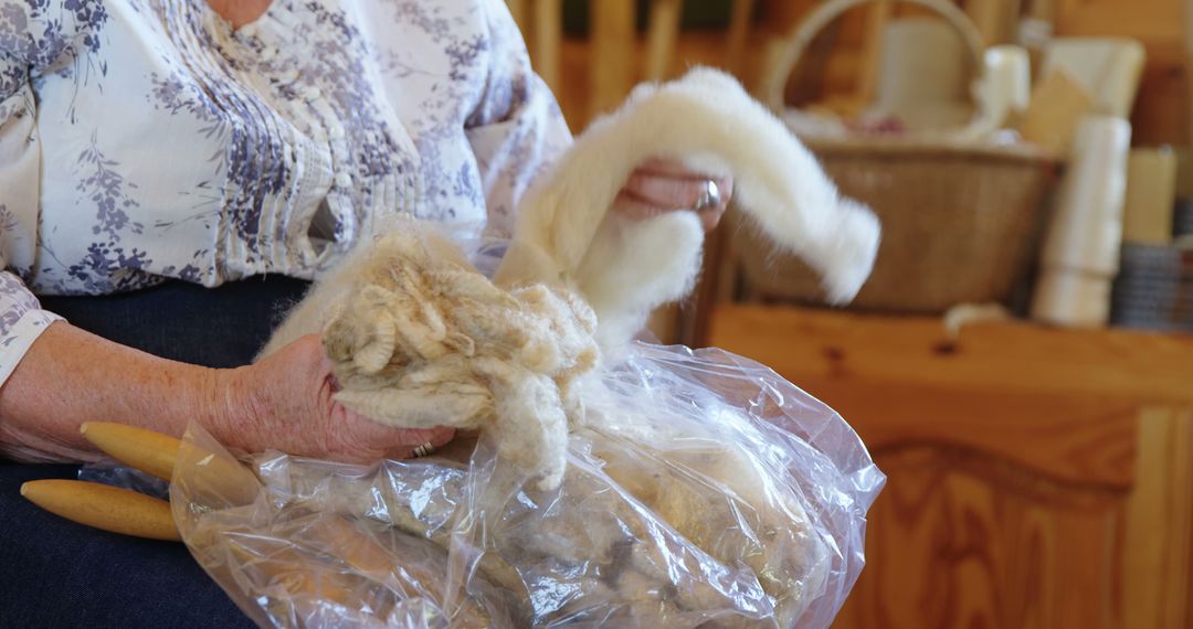 Senior Woman Spinning Wool Yarn by Hand in Rustic Setting - Free Images, Stock Photos and Pictures on Pikwizard.com