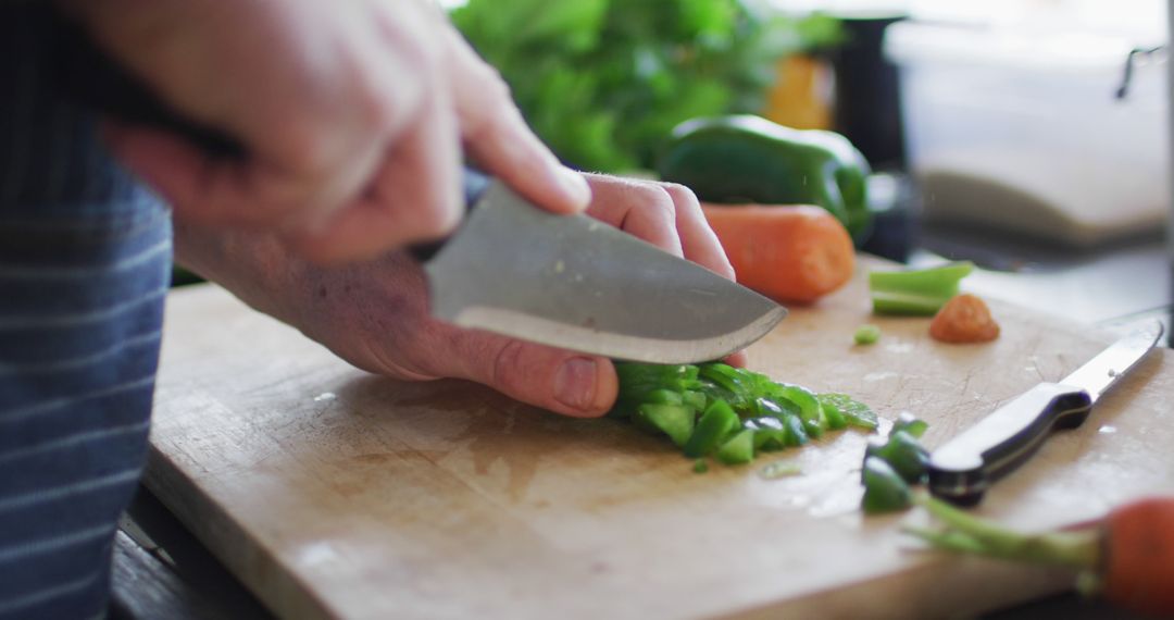 Close-up of hands chopping green bell pepper on wooden cutting board - Free Images, Stock Photos and Pictures on Pikwizard.com