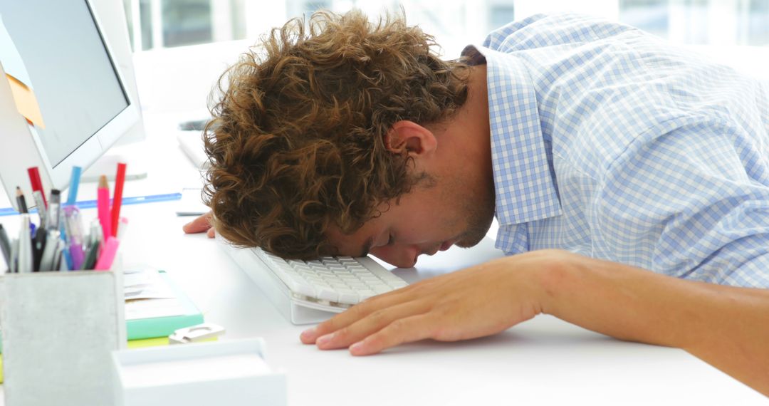 Exhausted Office Worker Sleeping on Keyboard at Work Desk - Free Images, Stock Photos and Pictures on Pikwizard.com