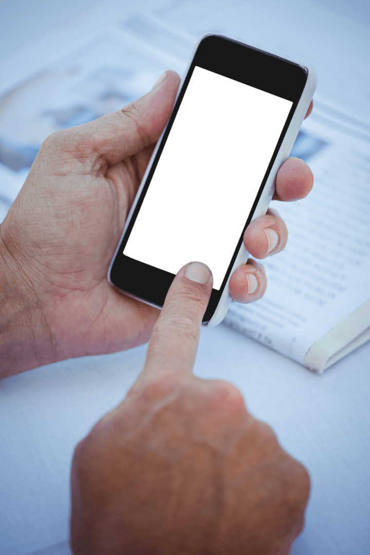 Close-Up of Hand Using Transparent Smartphone Over Newspaper