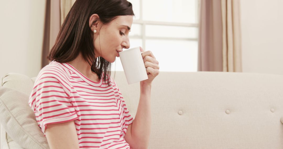 Relaxed Woman Sipping Coffee on Sofa at Home