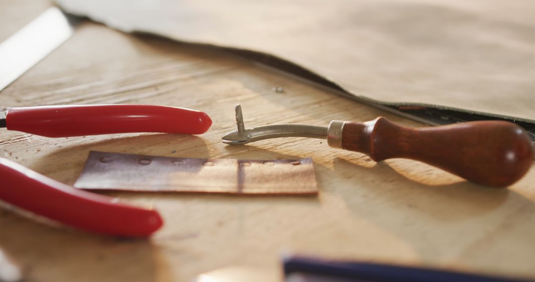 Close-up of Essential Leatherworking Tools on Wooden Surface