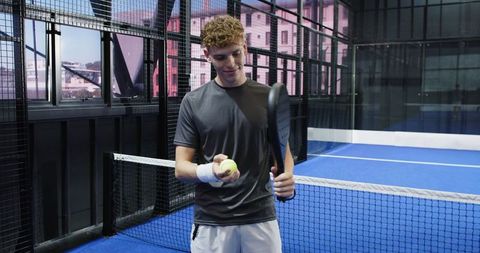 Young Man Ready to Serve on Modern Blue Padel Court