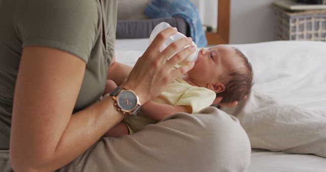 Image of midsection of caucasian mother feeding newborn baby with bottle on bed - Download Free Stock Photos Pikwizard.com