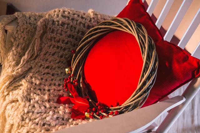 Close-up of grapevine wreath with red pillow on chair