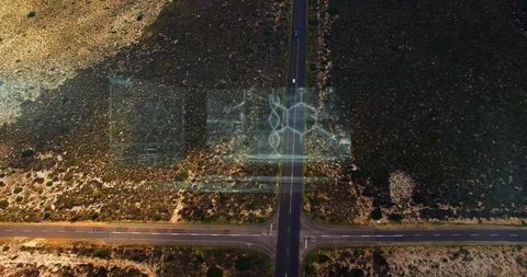 Drone aerial desert crossroads with holographic overlay and single car on intersection