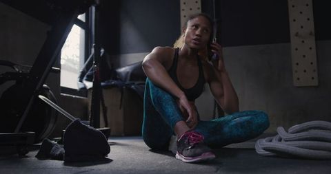 Biracial Athlete Resting in Gym Using Smartphone