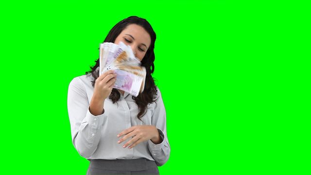 Businesswoman dressed in professional attire holds euro bills as a fan. Ideal for representing themes of wealth, success, and smart investments. Can be used in financial advice, business promotions, or advertising campaigns emphasizing prosperity and creativity in financial contexts.