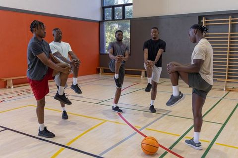 African american men stretching on basketball court during warmup and mobility drills