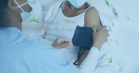 Nurse measuring blood pressure at bedside with cuff and augmented holographic monitoring