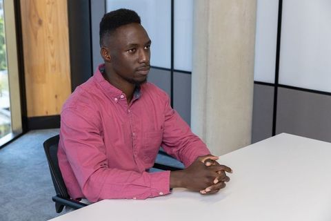 Businessman in pink shirt sitting at modern office desk