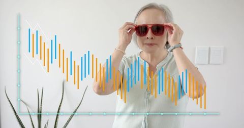Adjusting sunglasses senior asian woman wearing red shades with data overlay
