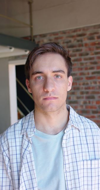 Young Man in Casual Shirt Standing Indoors - Download Free Stock Images Pikwizard.com