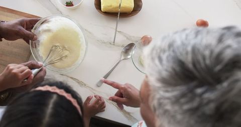 Grandmother Teaching Granddaughter Baking in Kitchen Together