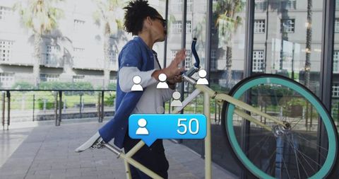 Urban commuter pushing pastel bicycle past glass facade with social followers notification