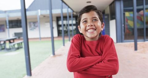 Confident Young Boy Smiling in School Courtyard