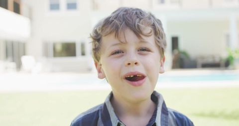 Happy Boy Smiling at Camera Outside Stylish Home