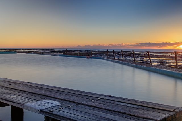 Calm Ocean Pool at Sunrise with Wooden Deck - Download Free Stock Images Pikwizard.com