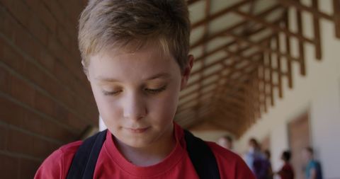Young Schoolboy Deep in Thought in School Corridor